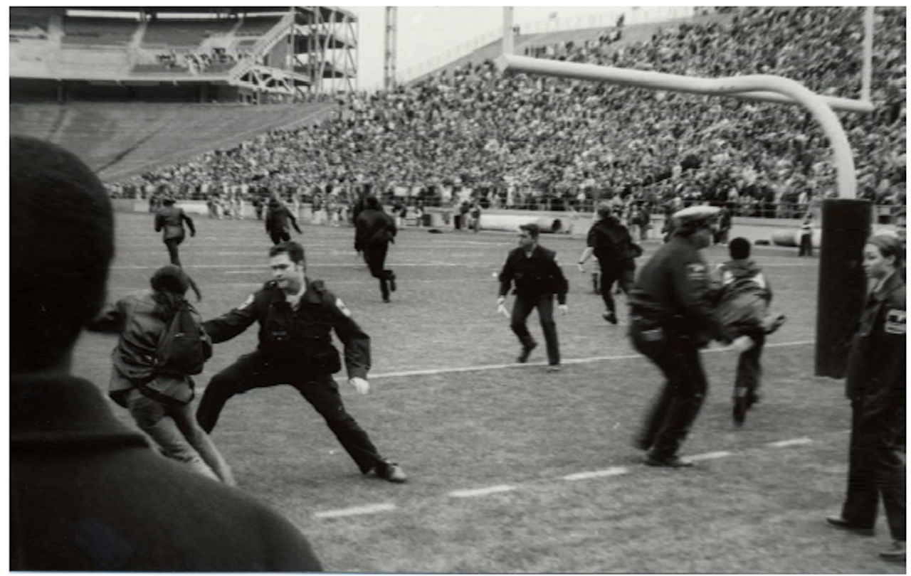 Students rush on the field of Beaver Stadium to protest and are met by police