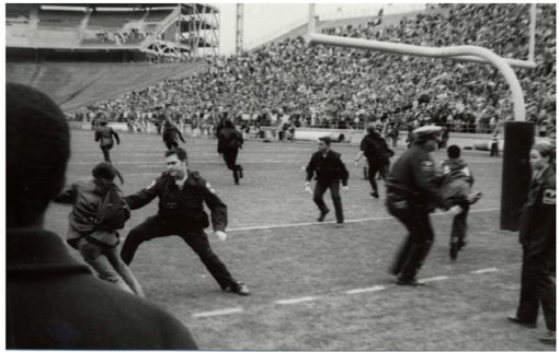 Students rush on the field of Beaver Stadium to protest and are met by police
